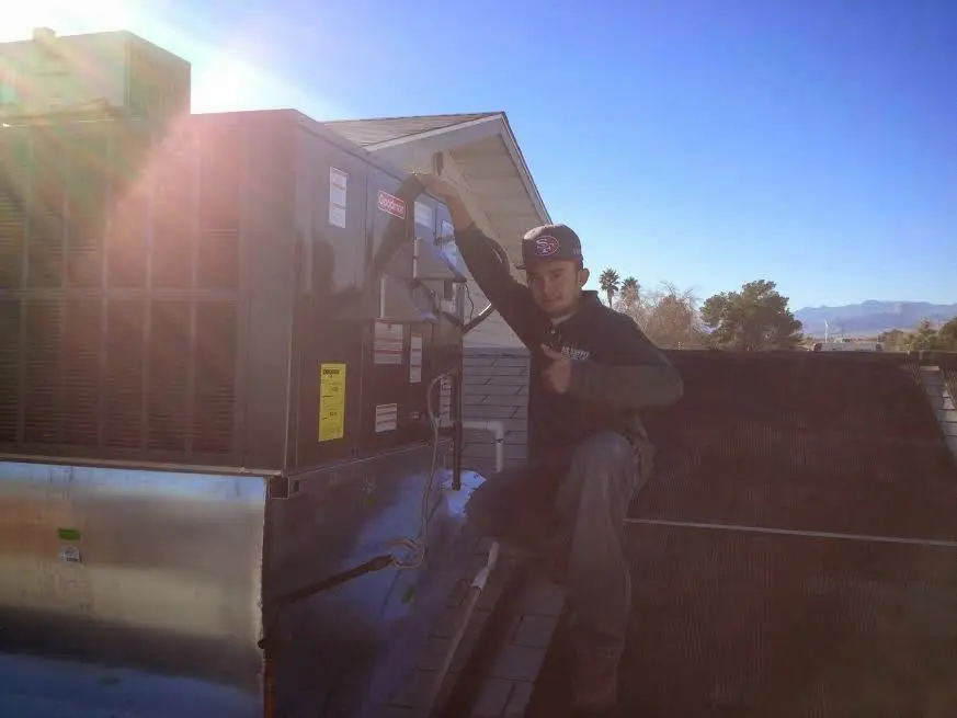 HVAC technician performing AC Tune-Up on a rooftop unit in Pemberton